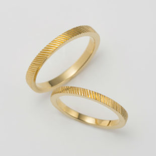 カジュアルな彫り模様のゴールドの結婚指輪