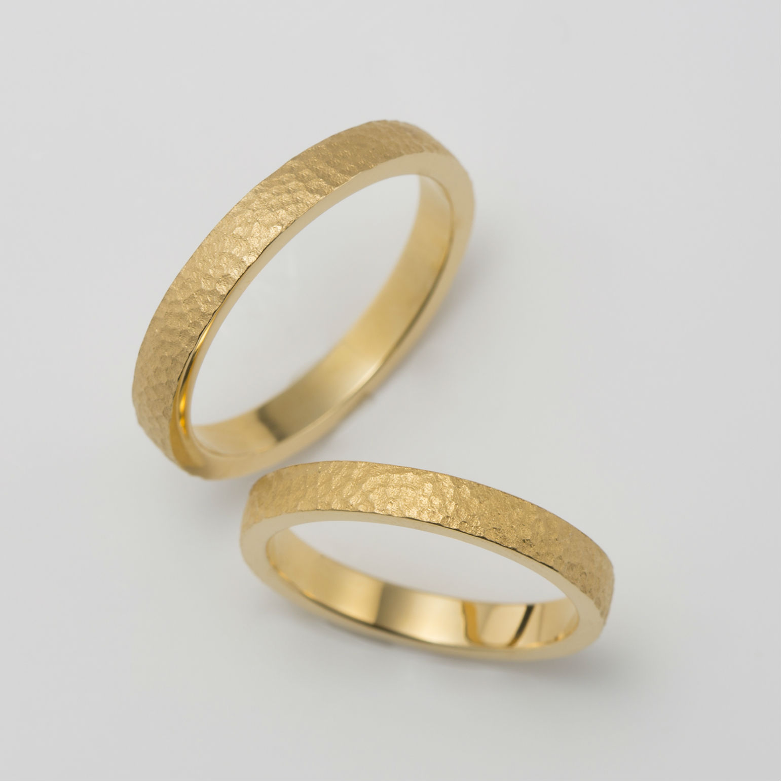 鎚目模様を施したイエローゴールドの結婚指輪