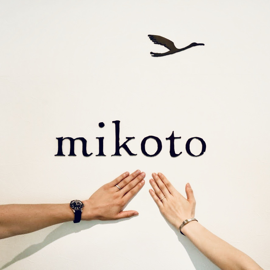 お客様の手と鶴(mikoto)のロゴ