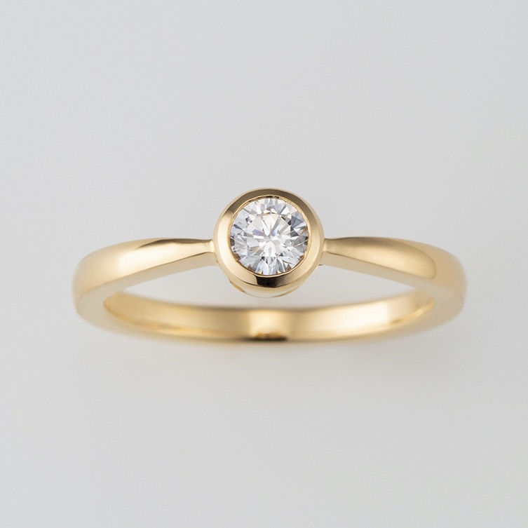指に馴染むゴールドのカジュアルな婚約指輪