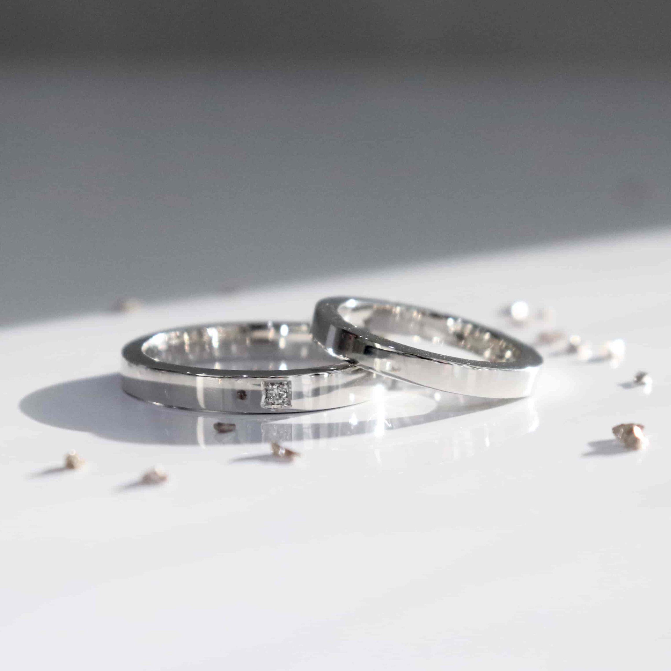 四角のダイヤモンドを留めた平打ちの結婚指輪